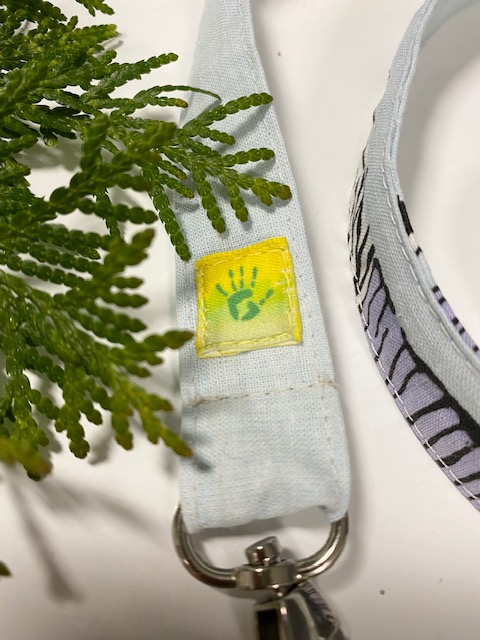 Kierrätyspussilakanasta syntyi muumilaukku, jonka hihnassa komeilee Värikkään Kädenjäljen logo.