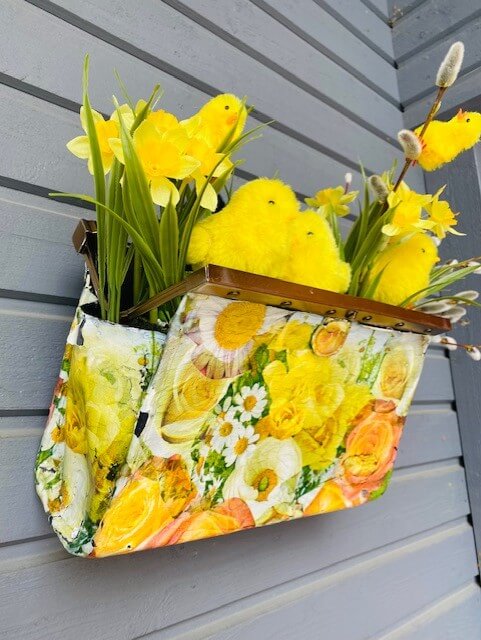 Pääsiäsiasetelma voi olla näinkin ihastuttava! Vintage-laukusta saa tuunaamalla iloisen kukkalaukun, joka toimii myös pääsiäisasetelmana.